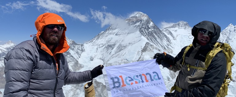 Two men stand atop everest with a Blesma Banner