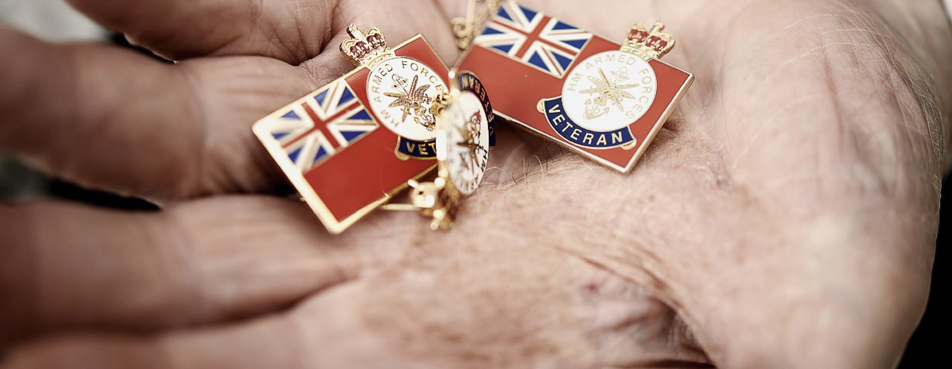 Veteran pensioner holds out HM Armed Forces Veteran badges